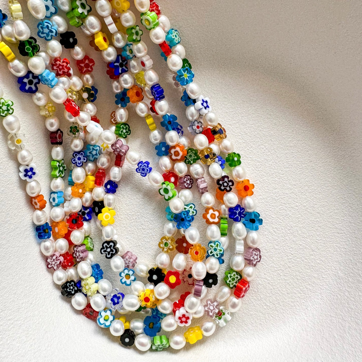DAISY NECKLACE close-up showing vibrant millefiori glass daisy flowers and pearl details